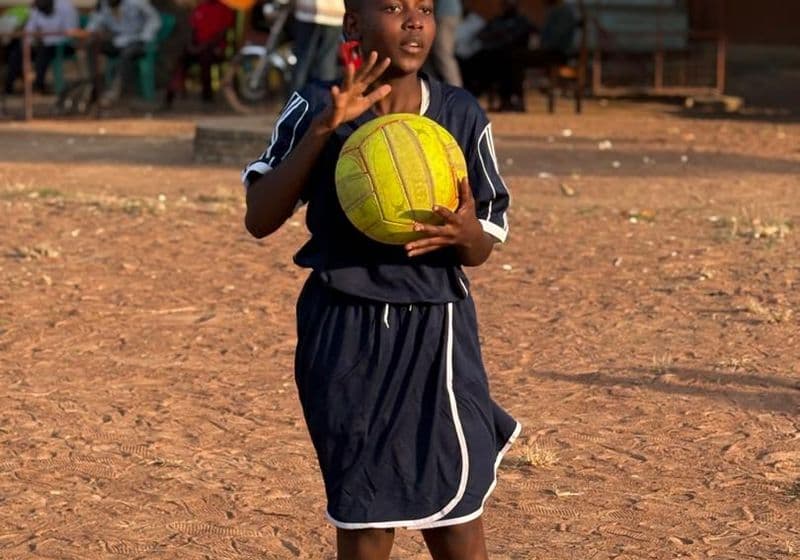 A Bidii Schools student holding the ball on the netball court