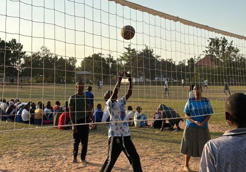 A student spiking the ball at the net during a volleyball match at Bidii Schools