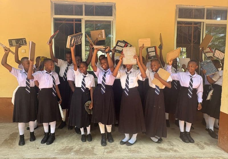 Students celebrating with their books outside a Bidii Schools classroom